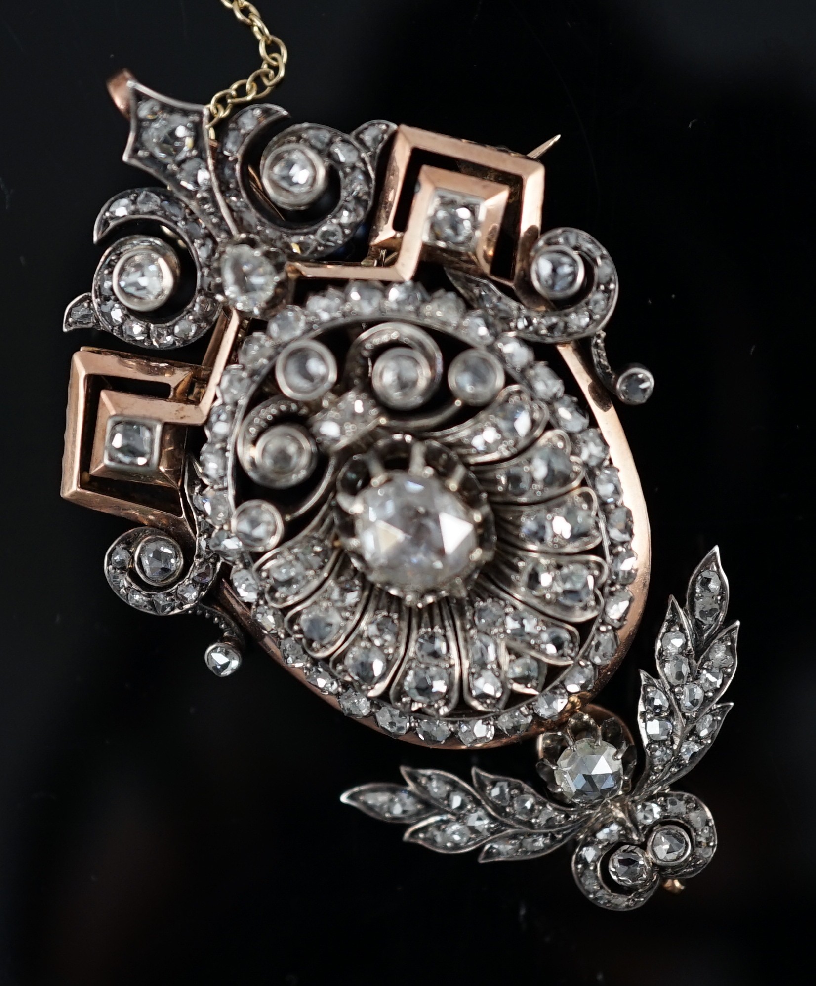 A late 19th/early 20th century pierced gold, silver and graduated rose cut diamond cluster set pendant brooch